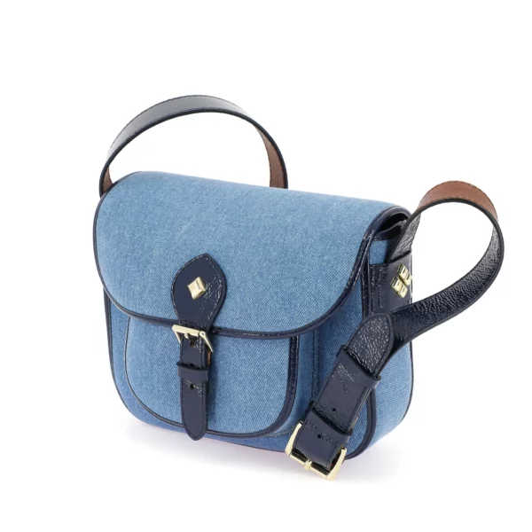 Sac gibecière en denim délavé avec empiècements en cuir vernis marine, anse ajustable et bijouterie dorée, modèle Le Flav de Herbert Frère Sœur.