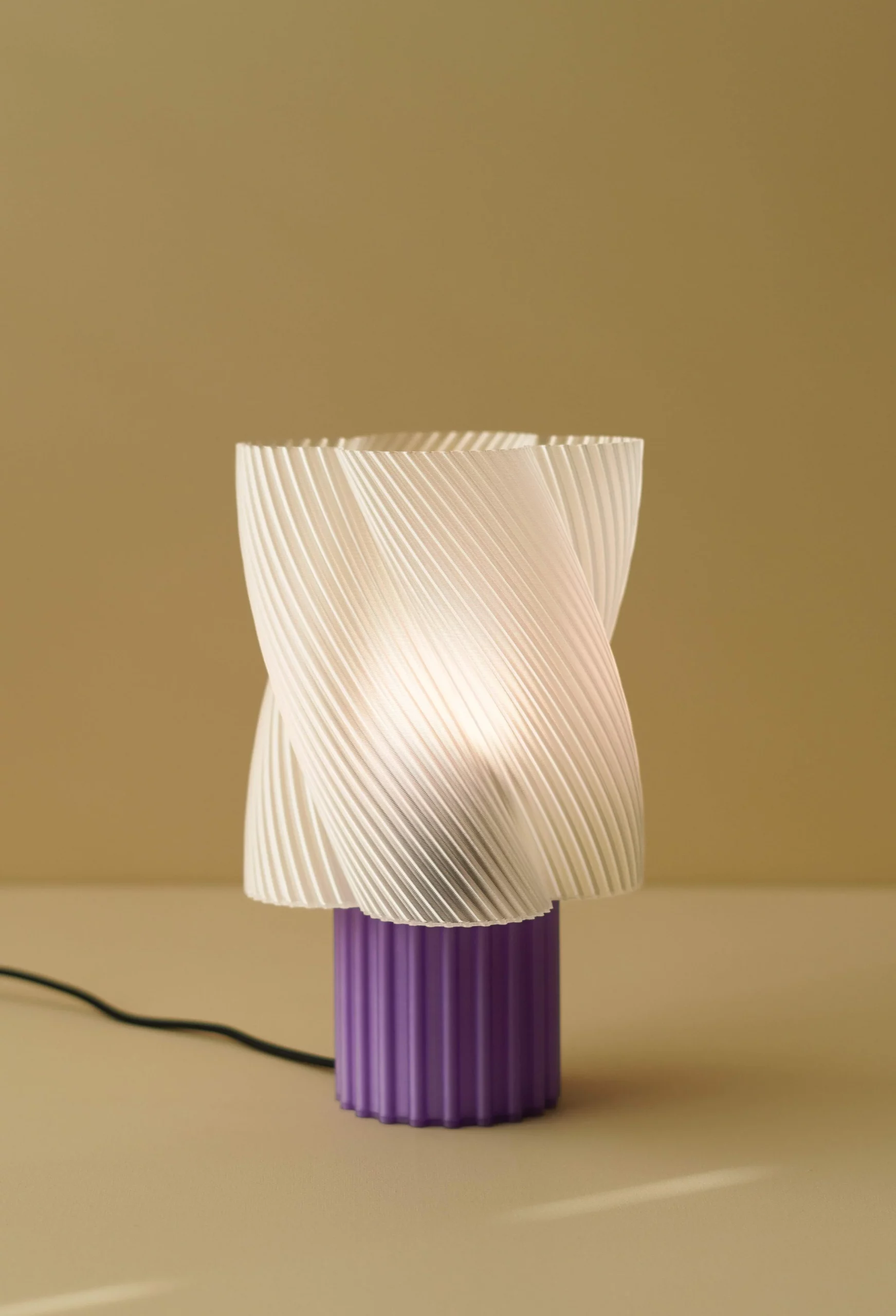 Lampe design en amidon de maïs biodégradable, coloris lait-violette, avec cordon textile noir.