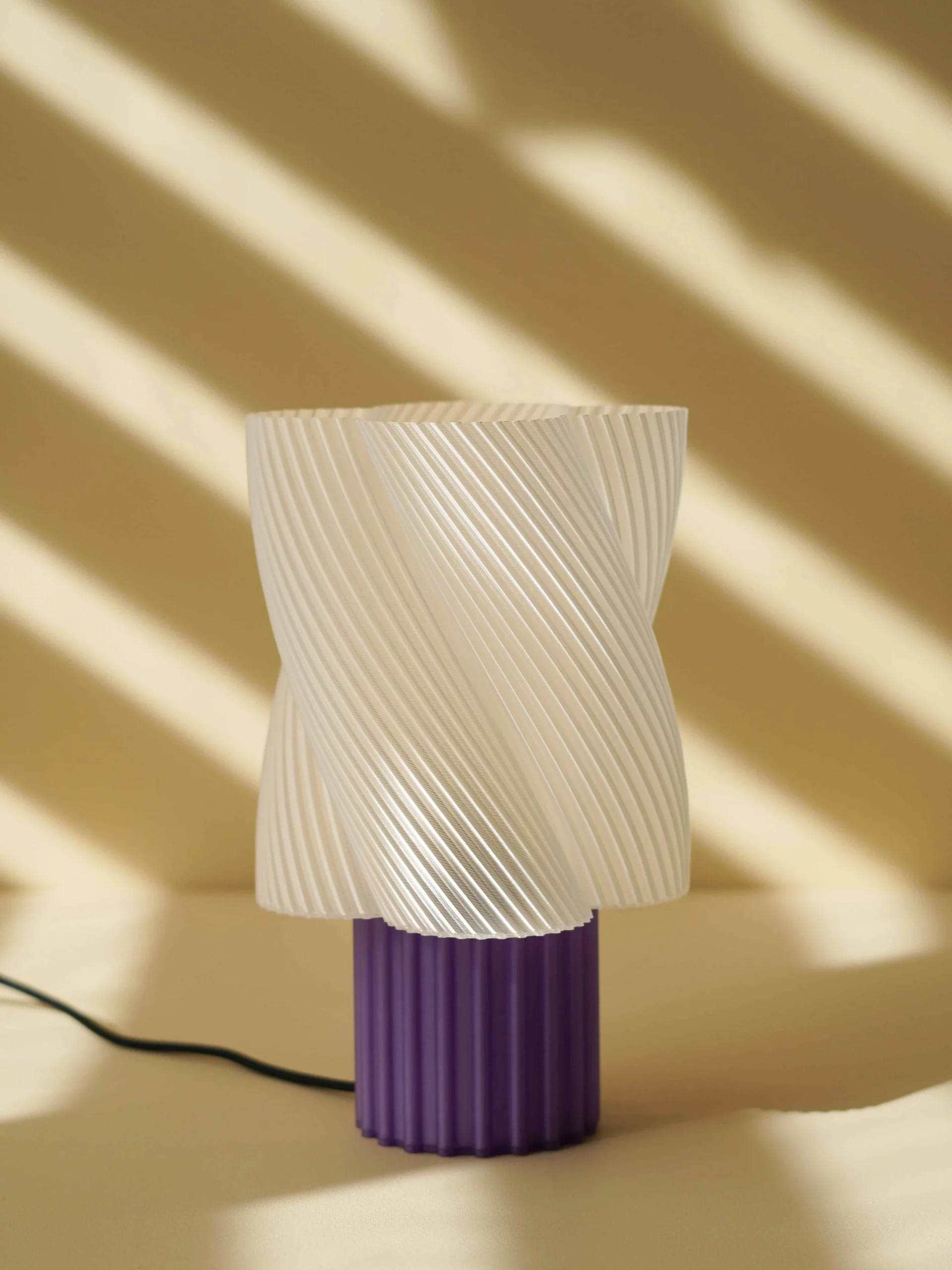 Lampe design en amidon de maïs biodégradable, coloris lait-violette, avec cordon textile noir.