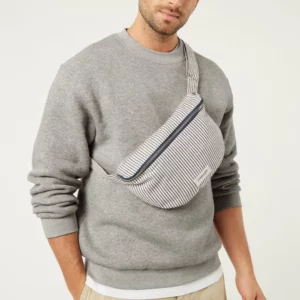 Sac banane Custine rayé bleu marine et blanc en coton recyclé et organique, avec anse ajustable et zip argenté.