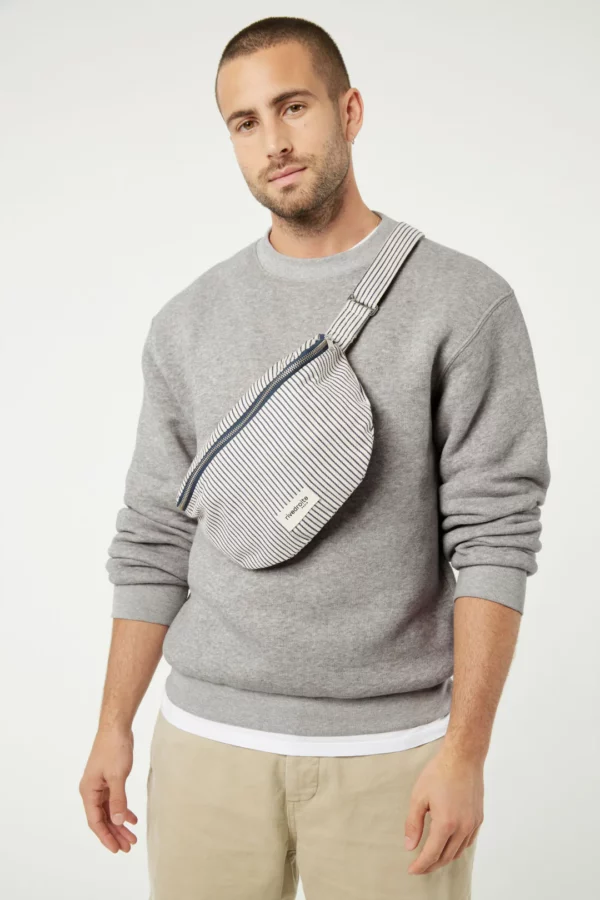 Sac banane Custine rayé bleu marine et blanc en coton recyclé et organique, avec anse ajustable et zip argenté.