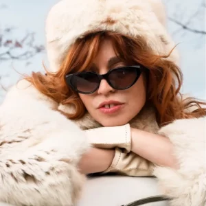 Lunettes de soleil noires rétro JADE de IYU DESIGN portées par une femme élégante en extérieur