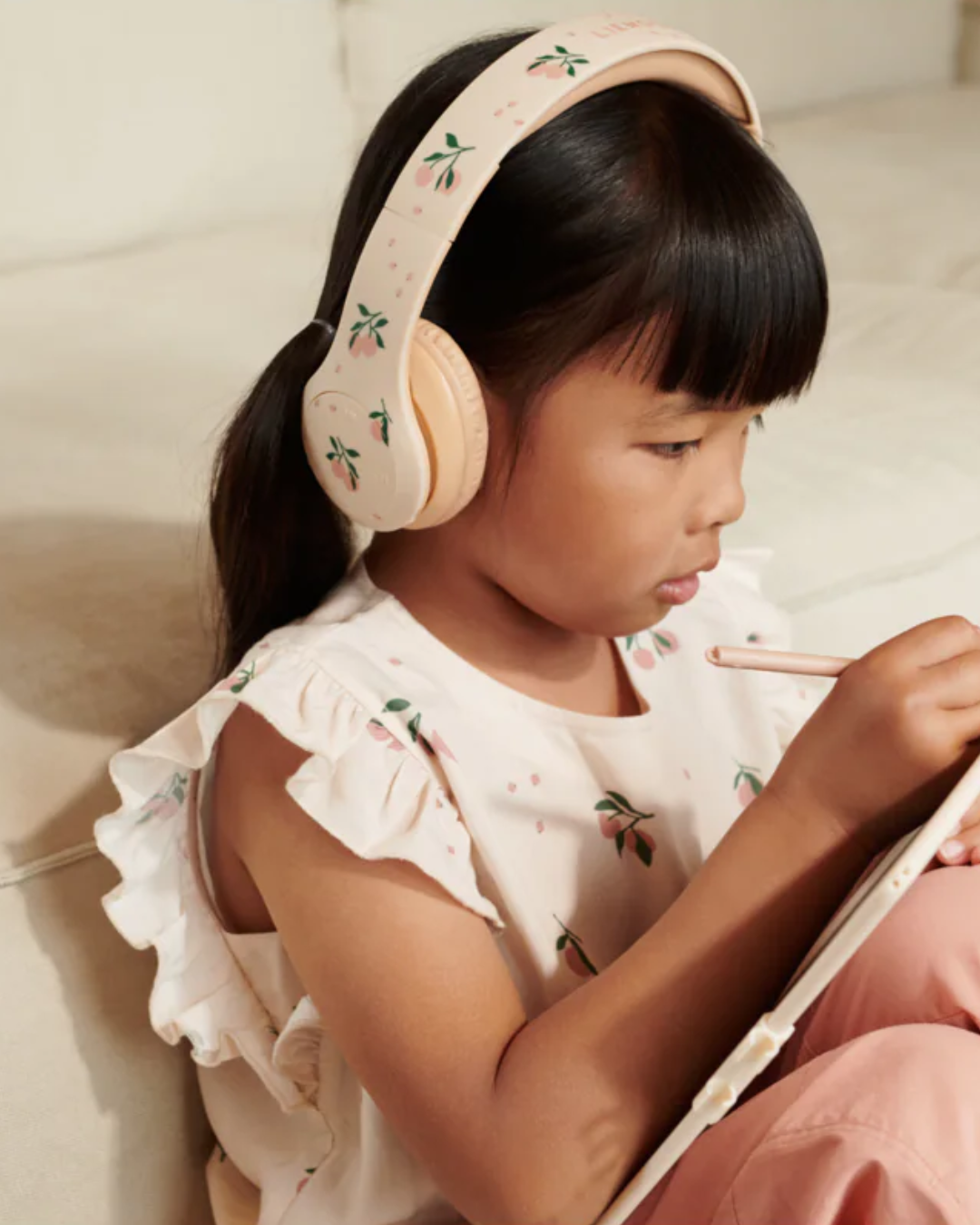 Casque audio sans fil pour enfant QUINN – coloris pêche, pliable, avec limite sonore 85 dB et coussinets rembourrés.