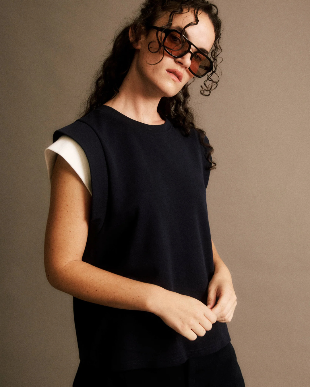 T-shirt Claudine JIJI Studio en maille et coton bleu marine, sans manches avec détails aux épaules, taille S.