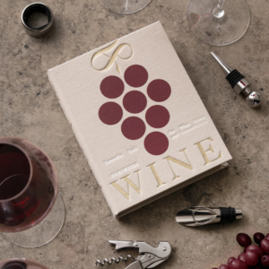 Coffret L’Essentiel du Vin beige en forme de livre, avec tire-bouchon, bouchon, verseur et col anti-gouttes.
