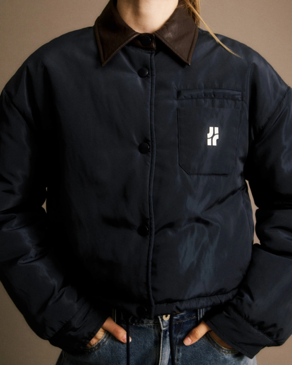 Doudoune Alixe bleu marine JIJI Studio, blouson matelassé court avec col marron contrasté, logo poitrine et cordon de serrage, taille S.