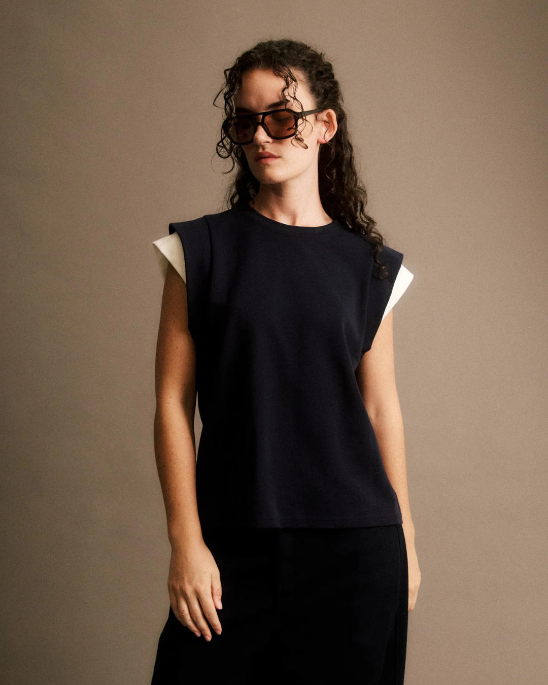 T-shirt Claudine JIJI Studio en maille et coton bleu marine, sans manches avec détails aux épaules, taille S.