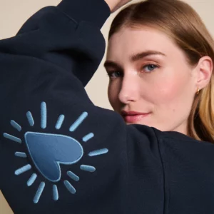 Sweat femme Cœur Solaire bleu en coton bio avec coudières brodées, signé émoi émoi.