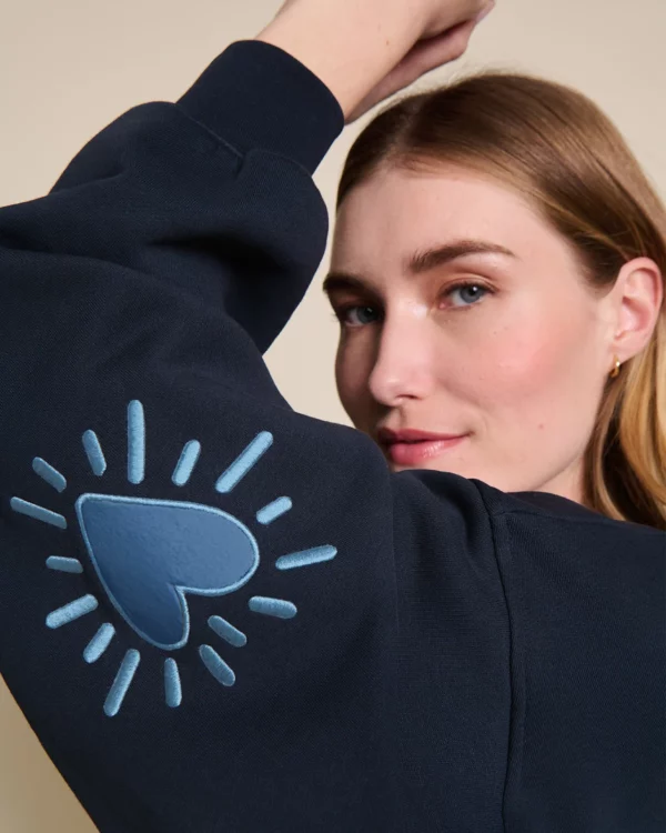 Sweat femme Cœur Solaire bleu en coton bio avec coudières brodées, signé émoi émoi.