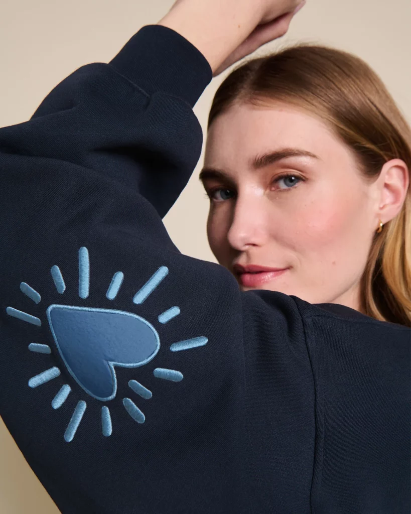 Sweat femme Cœur Solaire bleu en coton bio avec coudières brodées, signé émoi émoi.
