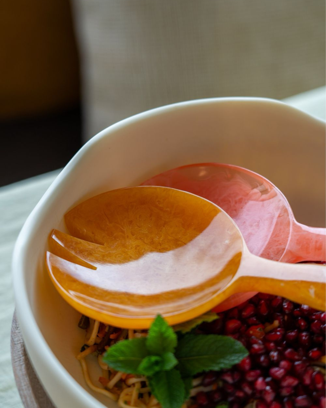 Apportez une touche joyeuse et raffinée à vos repas avec ces grands couverts à salade orange et rose signés Studio Noticed.