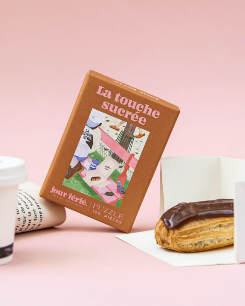 Mini puzzle 100 pièces La Touche Sucrée illustrant une pause gourmande avec un éclair au chocolat et un café.