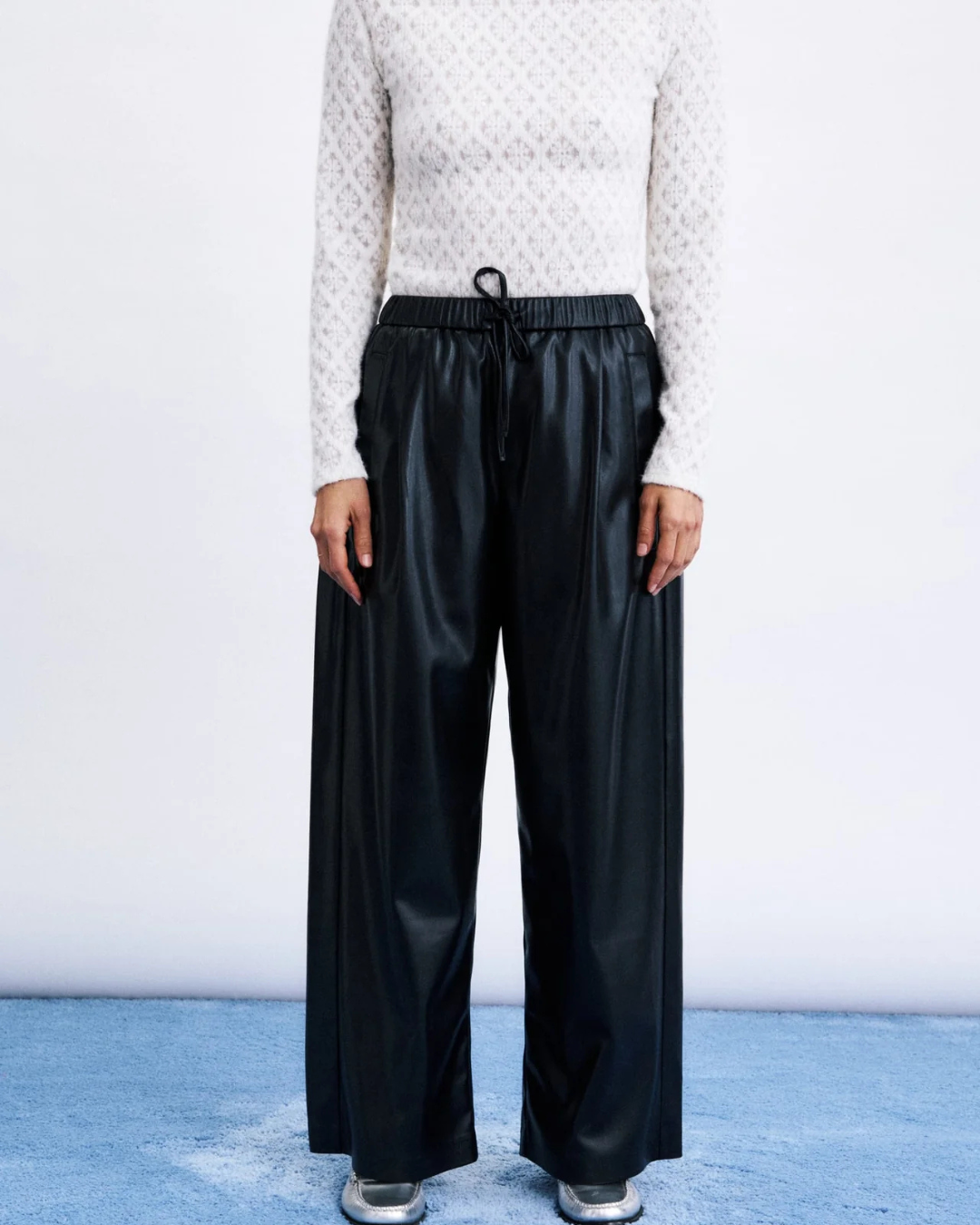 Le pantalon Odaesan Noir associe l’allure du simili cuir à une coupe large et décontractée. Sa taille haute élastiquée, son cordon de serrage et sa longueur 7/8 créent une silhouette moderne, confortable et facile à porter.