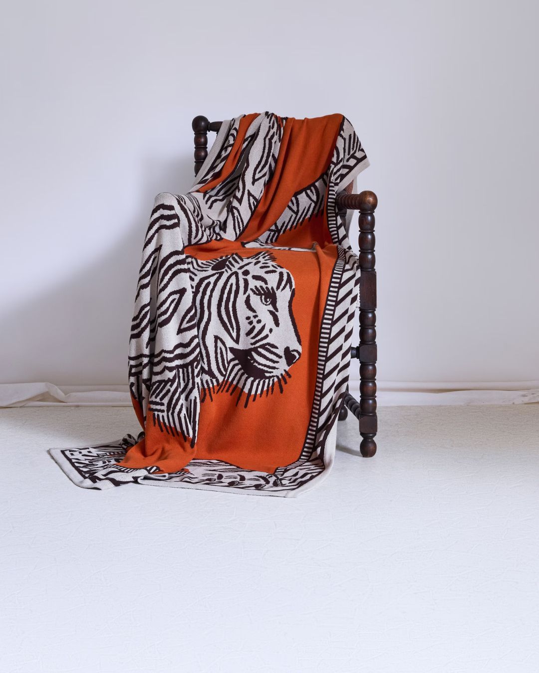 Plaid Mantra Orange Inoui Editions en 100 % coton de 130 × 190 cm avec motif tigre jacquard tissé.