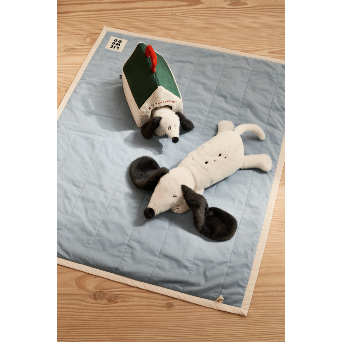 Peluche chien BERTO Liewood Sandy posée sur un plaid en tricot