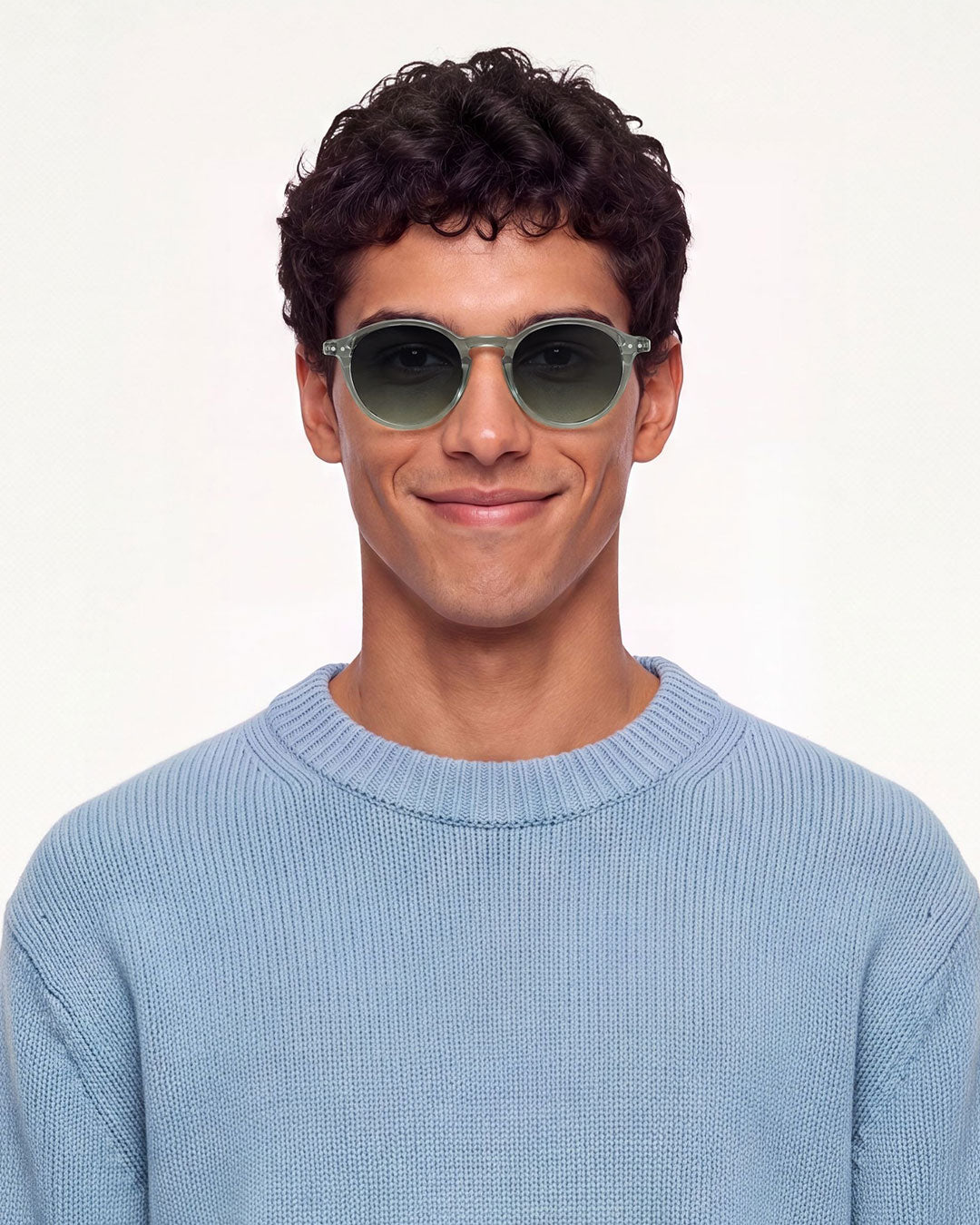 Homme en pull bleu clair portant les lunettes de soleil pantos Izipizi #D Station Seat vert pâle