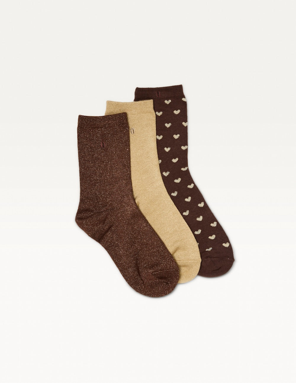 Trois paires de chaussettes Odaje à plat : marron pailletée, champagne pailletée et marron à petits cœurs clairs
