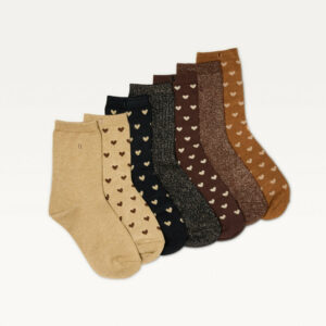 Les sept paires de chaussettes du semainier Odaje disposées en éventail : beige, caramel, marron et noir, à cœurs et paillettes