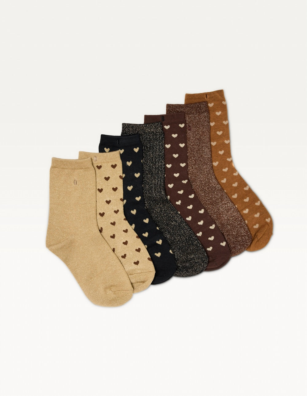 Les sept paires de chaussettes du semainier Odaje disposées en éventail : beige, caramel, marron et noir, à cœurs et paillettes